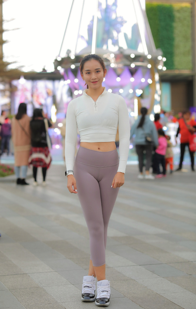 晨光中的城市广场,她以白色短上衣配浅紫瑜伽裤踏