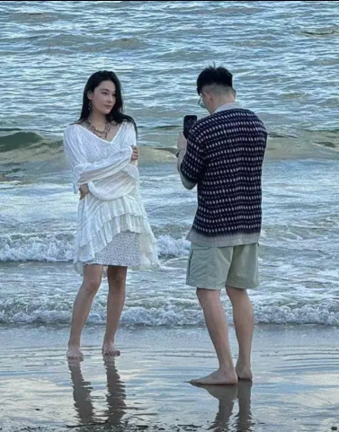 张馨予和军官老公何捷到海边度假,她穿着一条白色裙子,长发飘飘,何捷