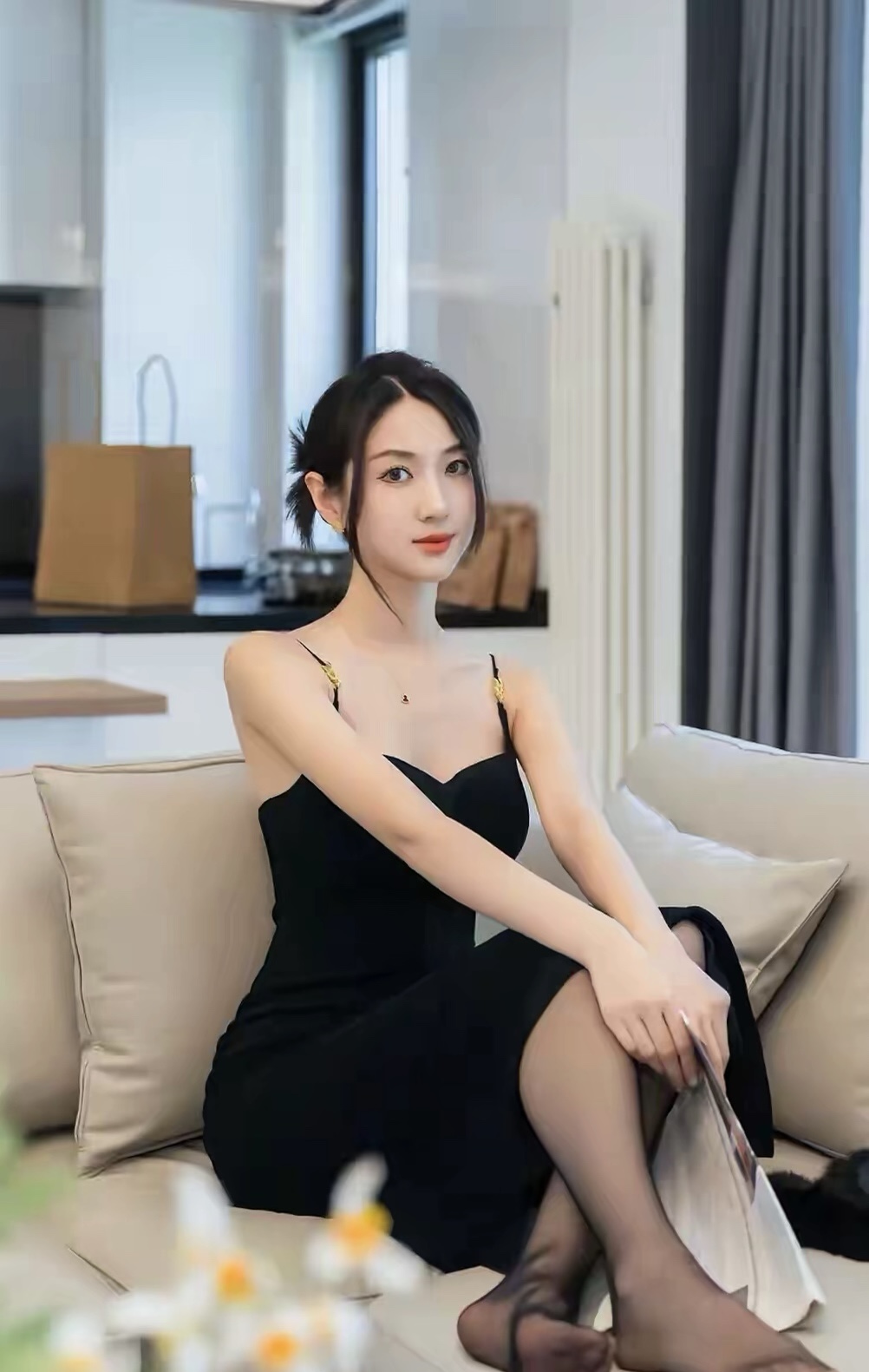 身着一袭黑色吊带连衣裙,我悠然自得地坐在桌前,指尖轻触手机屏幕,正