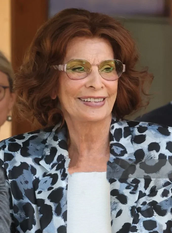 89岁的索菲亚·罗兰去年摔跤后第一次外出,拄着一根黑白相间的带斑点