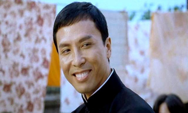 甄子丹一身笔挺中山装,胸前的政协委员徽章在阳光下泛着微光