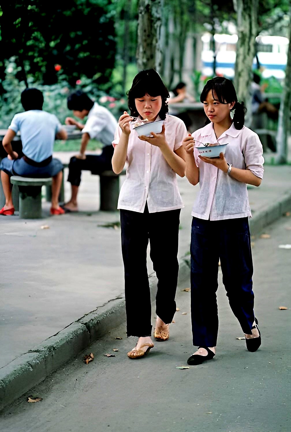 两个美丽的纺织女工,从食堂打完饭回宿舍,两人边走边吃