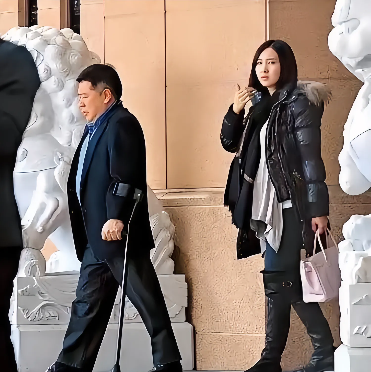 这是一张黎姿和她老公马廷强出行的照片,一个在前面走,一个在后面跟着