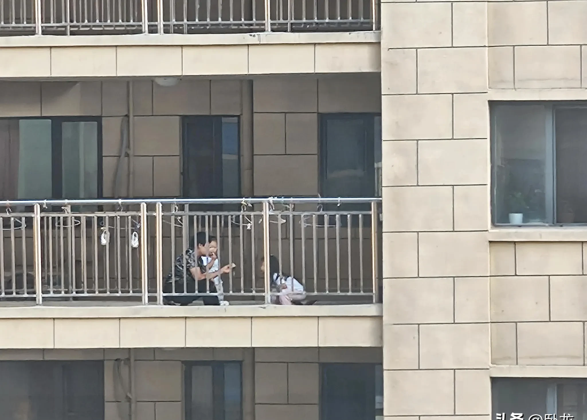 突然抬头一看,对面楼上连廊有一对小夫妻在外面吃饭