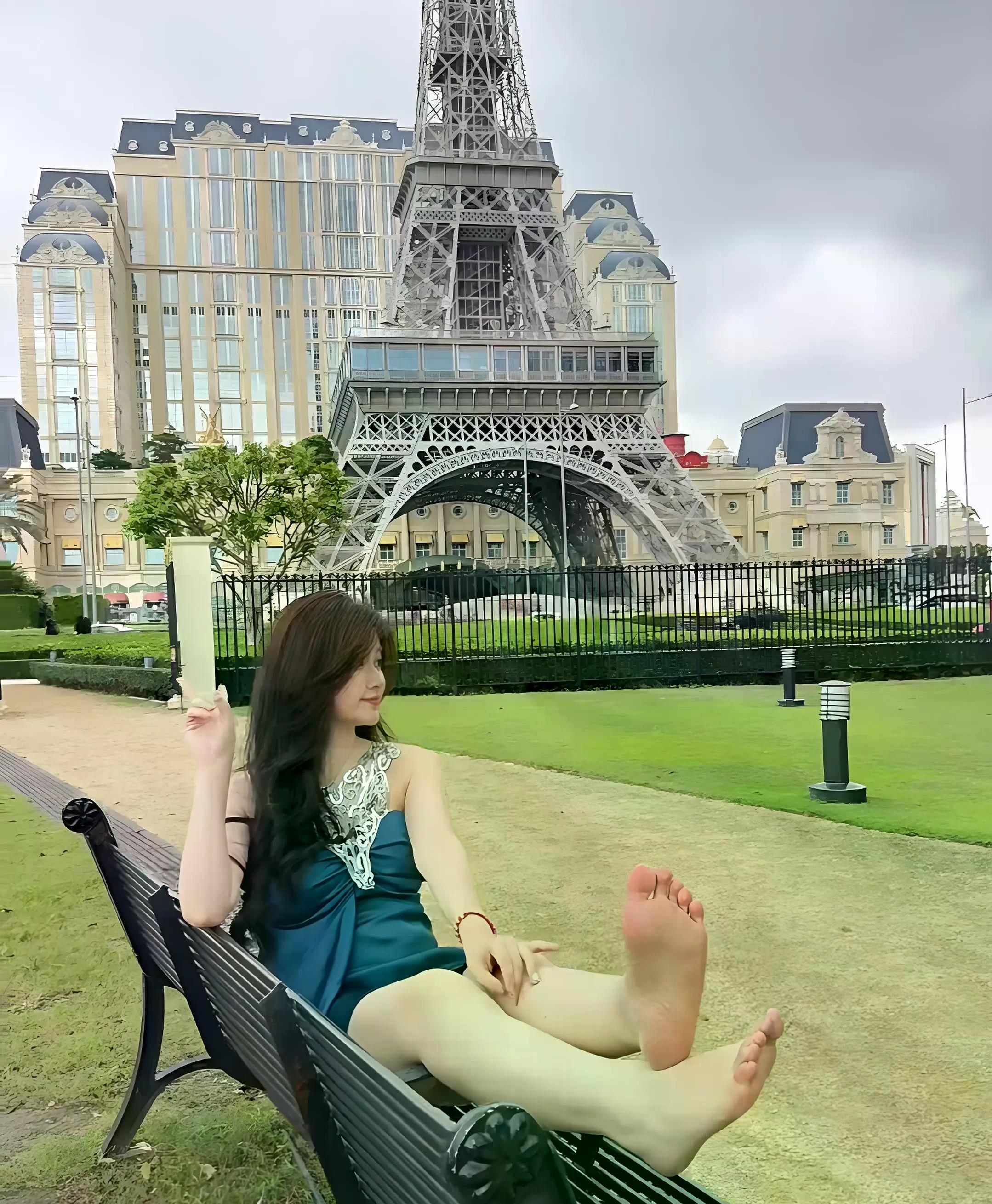 光着脚丫子坐在黑色的长凳上,两只脚丫随意伸着,嫩嫩的颜色,太抓眼球