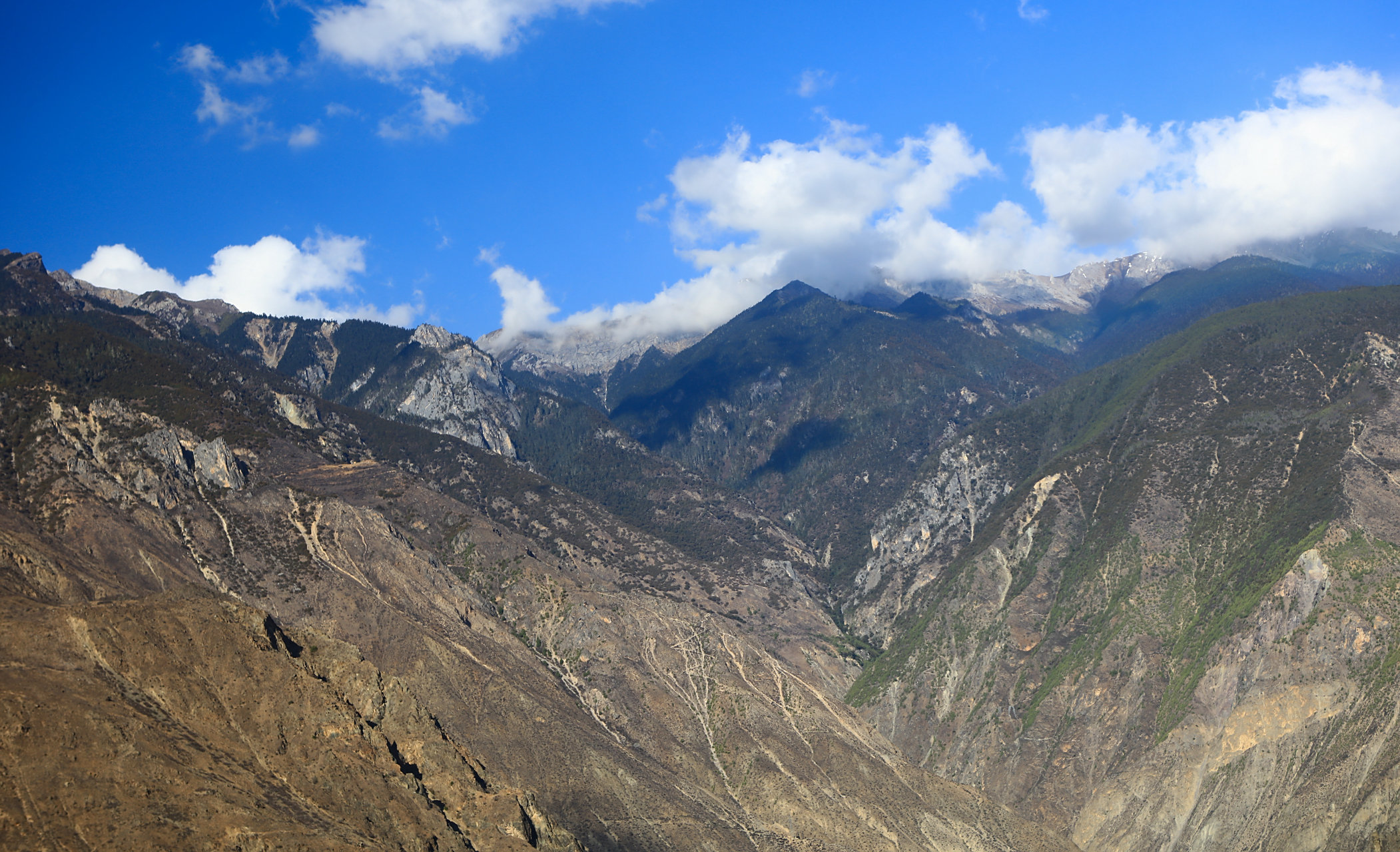 十万大山:云南梅里,澜沧江对岸的大山.远山山尖雪裹云涌,云卷云舒.
