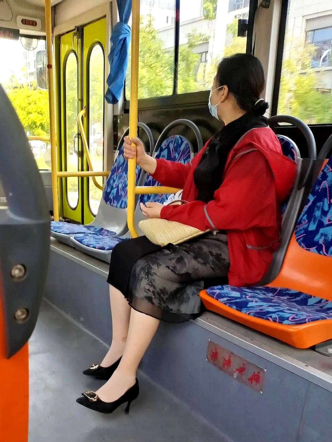 她穿一件黑色新中式纱裙,外面套了件大红色防晒服