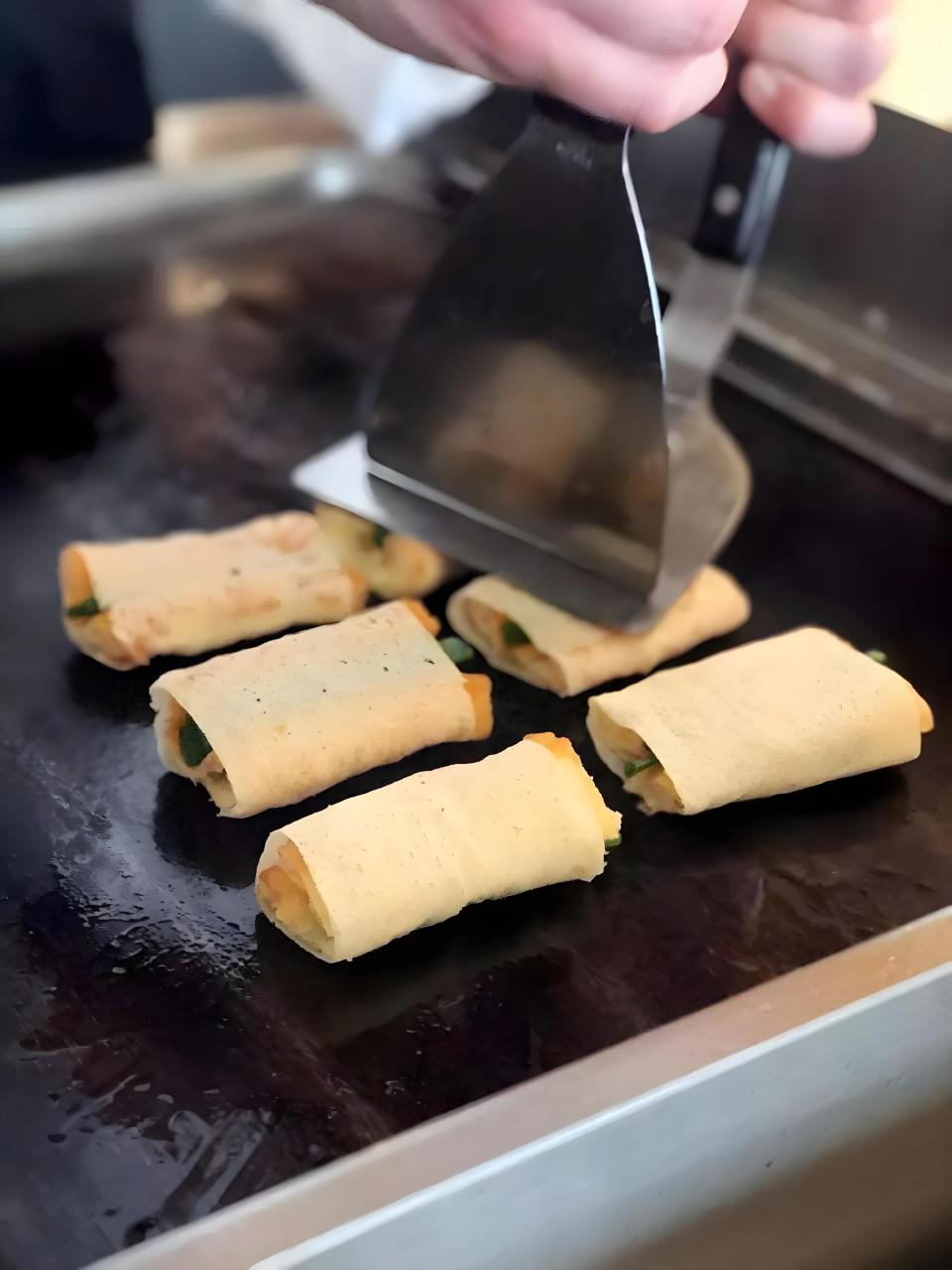 当时,百姓们为了表达对岳飞的怀念和对秦桧的憎恨,将油条和葱包裹在