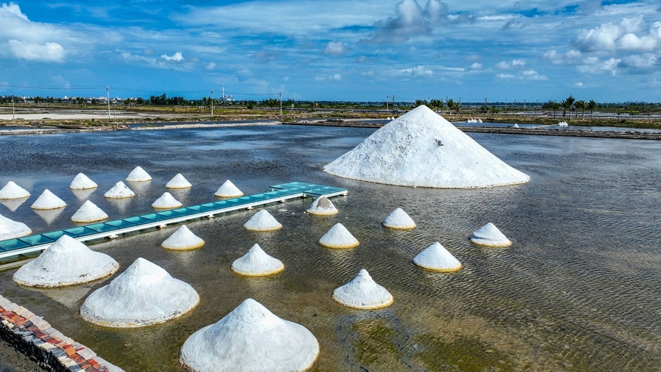 海南乐东莺歌海盐场,晨光如细丝般穿透薄雾,轻轻拂过每一块精心雕琢的