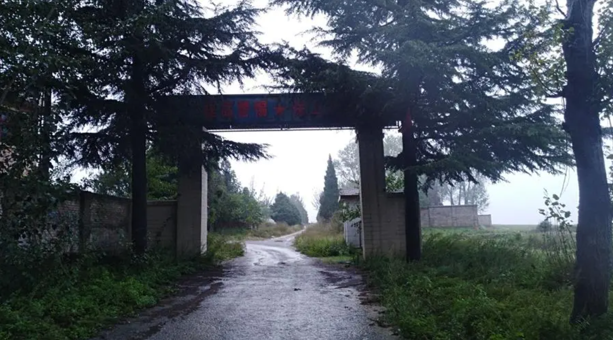 南门正对办公楼,由指挥连执勤.一人持枪站岗,军姿端正.