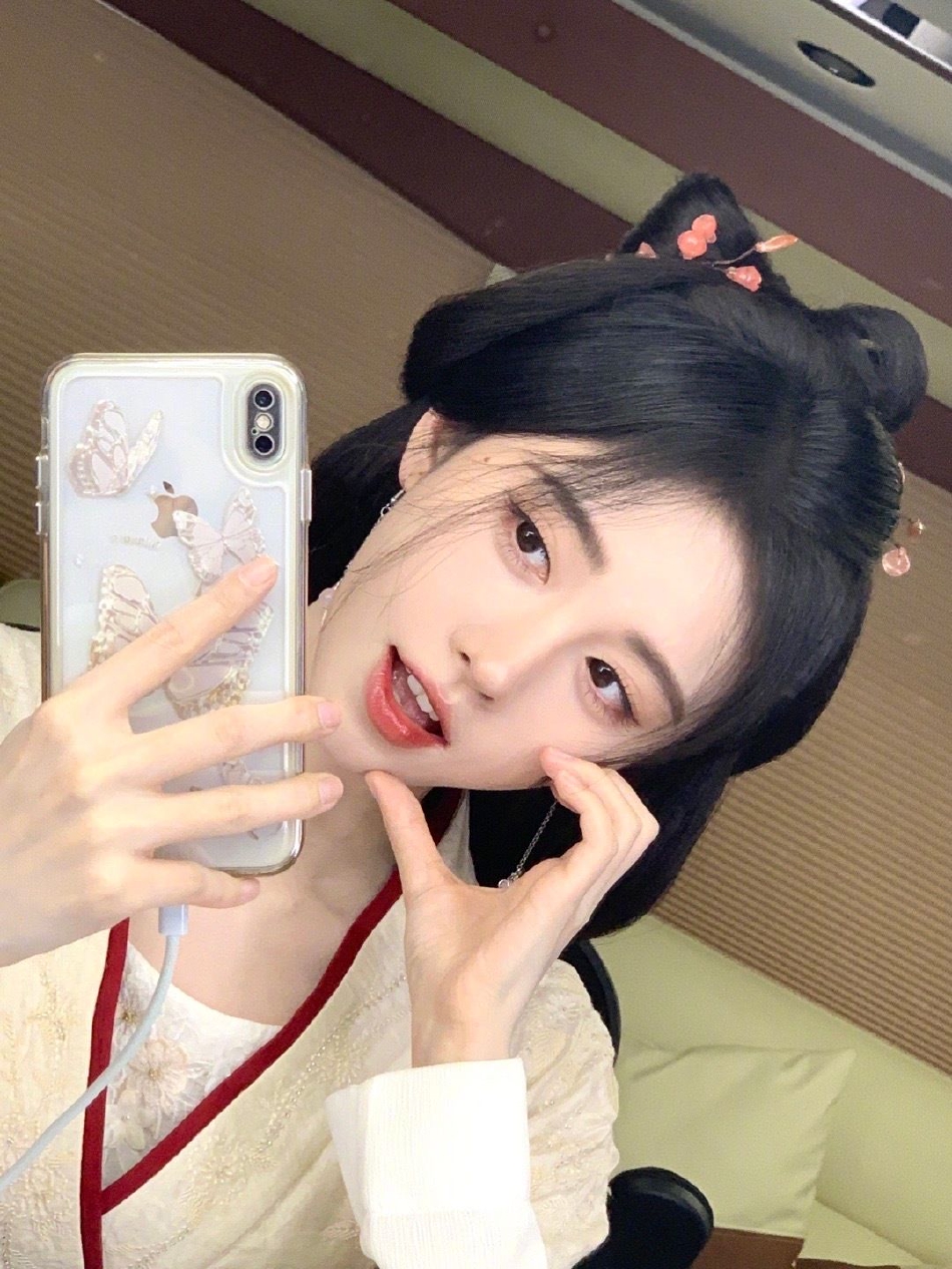 鞠婧祎拿着手机对镜自拍,脸颊比心卖萌好甜美