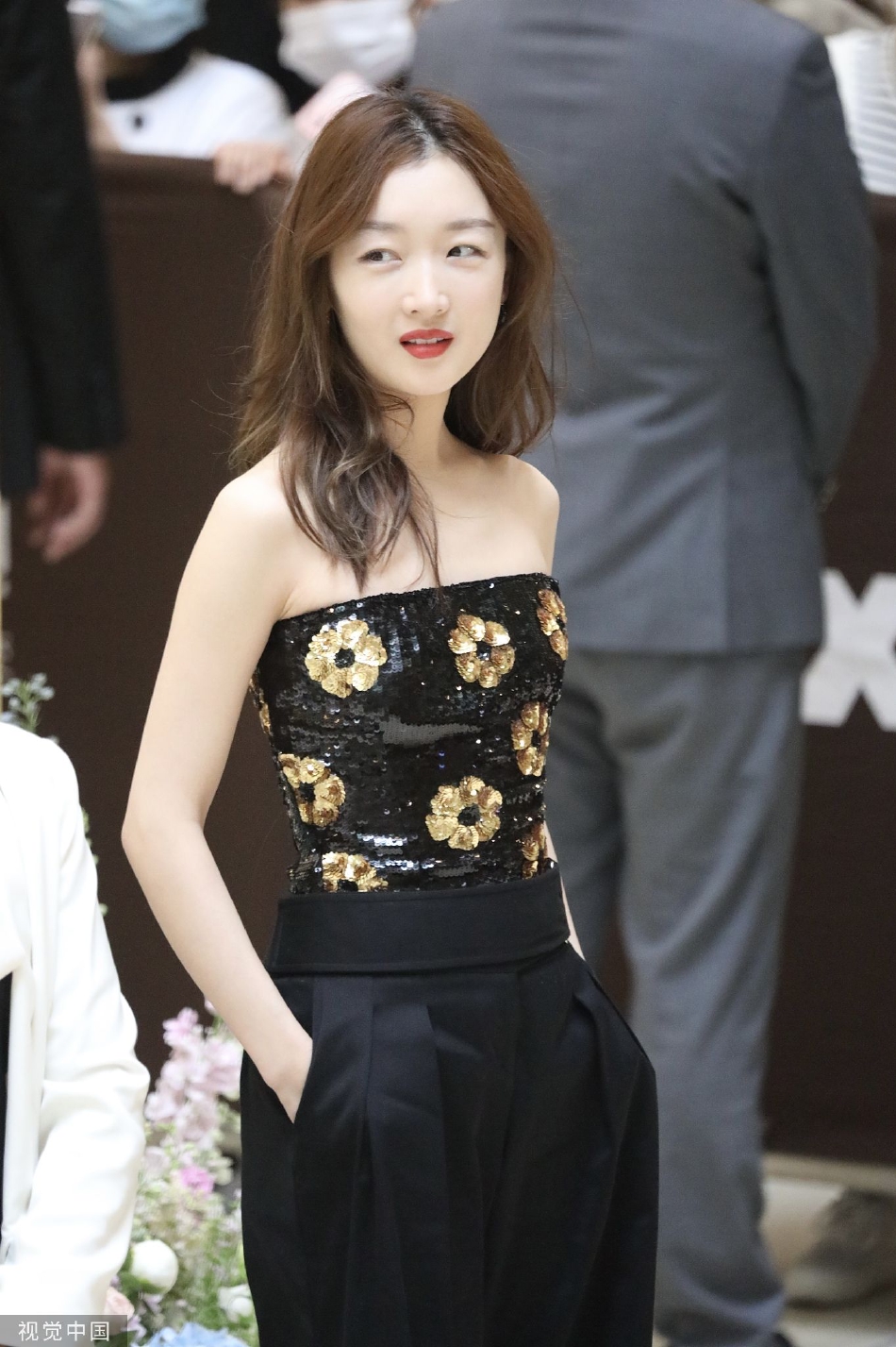 周冬雨穿花朵抹胸上衣搭配阔腿裤出席活动,长发披肩气质优雅,双手给