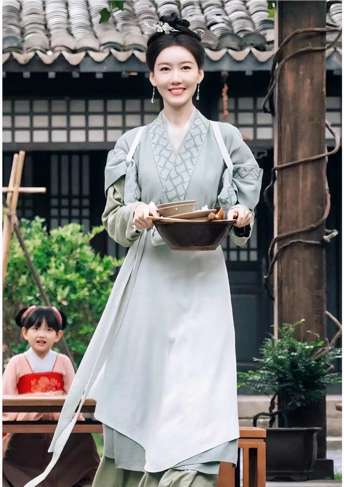 她旁边的小丫头头发扎成两个圆滚滚的小发髻粉粉嫩嫩的像个小橙子