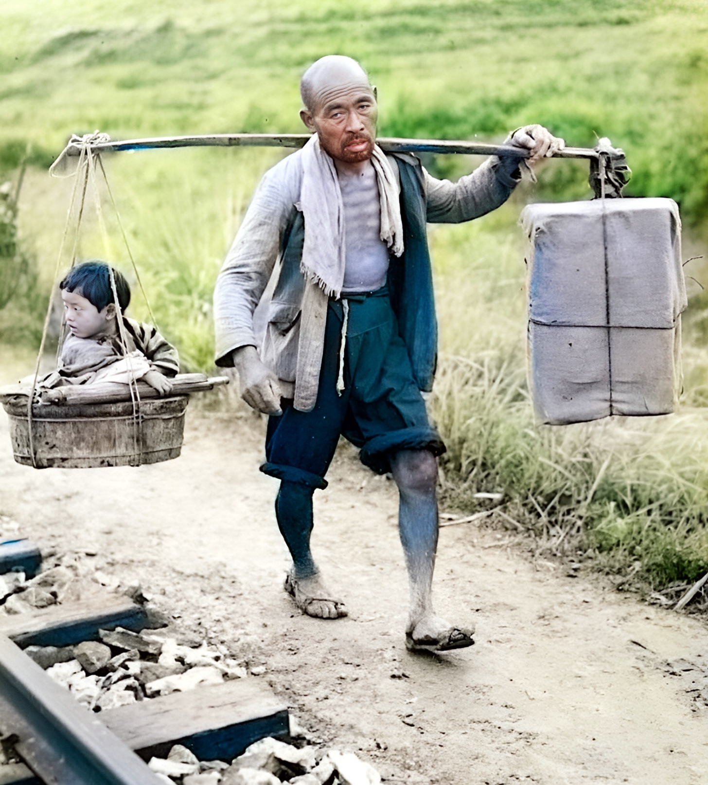 因无法抱着孩子,他将孩子放进前面的筐子里