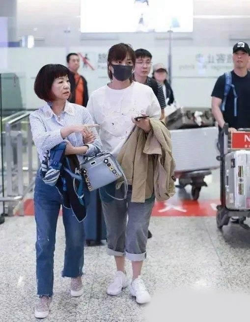徐静蕾近日和黄立行的妈妈一起亮相机场,她扎子个齐刘海的马尾,穿一件