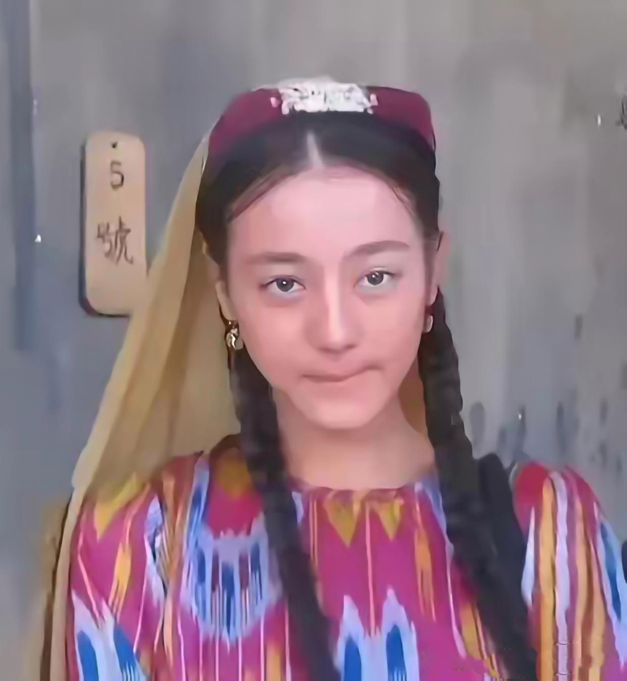 镜头下的她身穿传统的新疆服饰扎着两根长长的辫子略微有些害羞腼腆