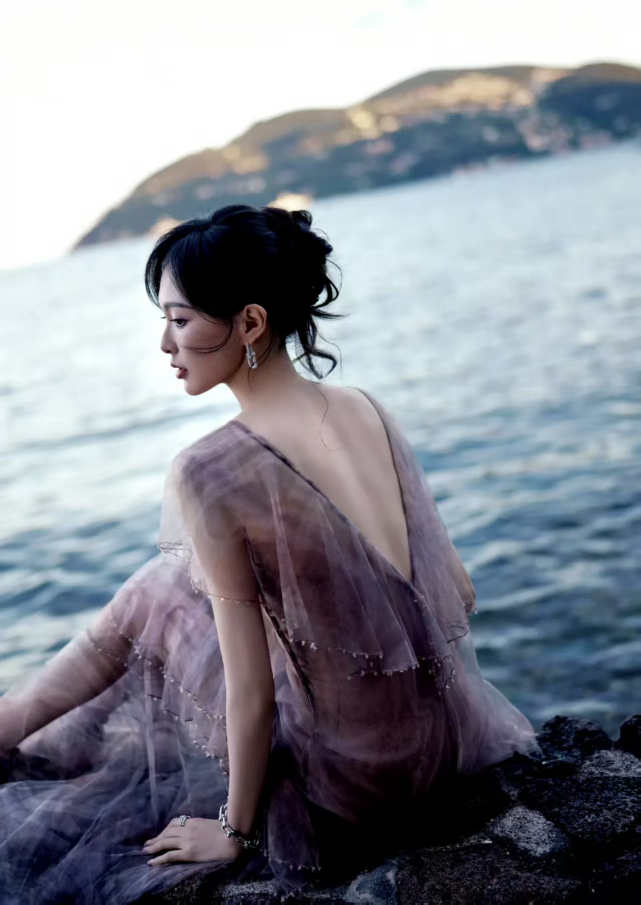 唐嫣身穿梦幻紫纱裙,站在古老的石墙边,宛如从童话中走出来的公主