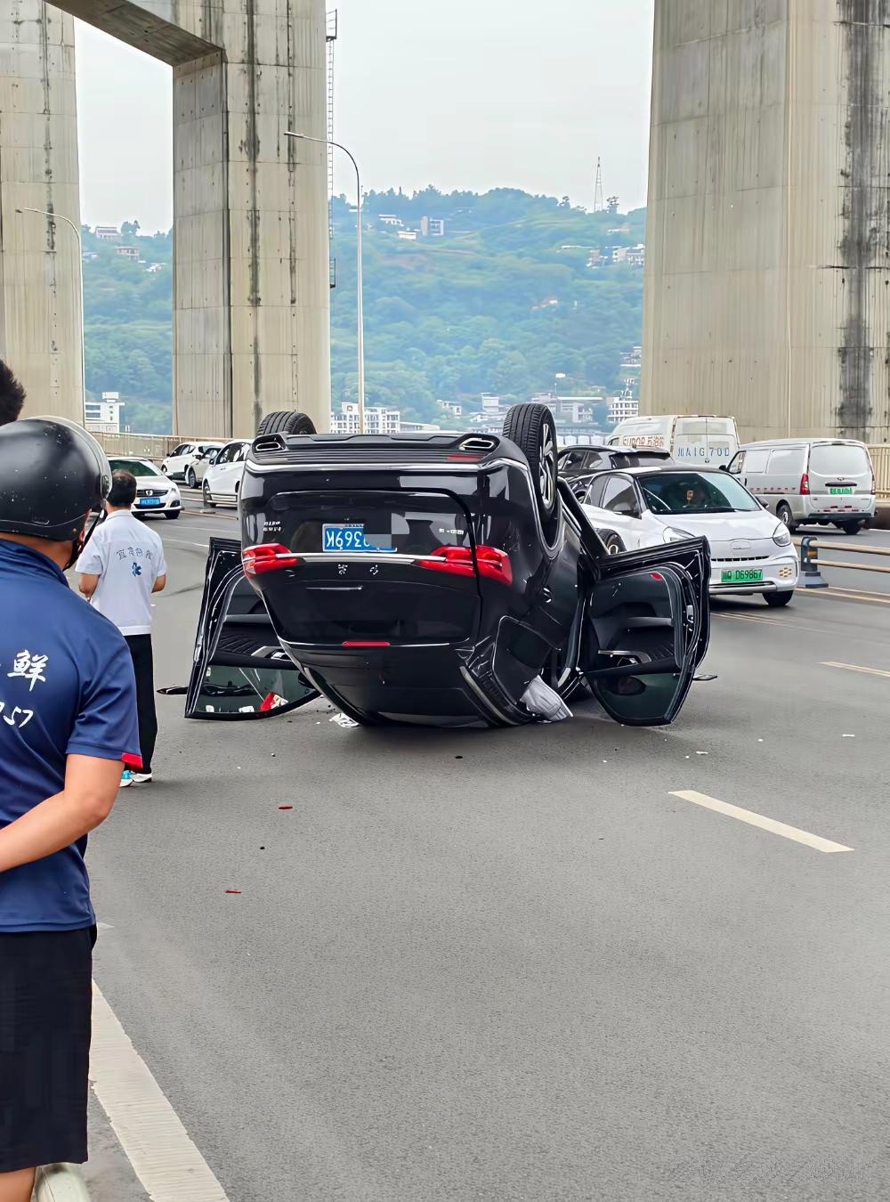 一辆黑色轿车狂飙着撞上桥边护栏,在桥面连翻两圈后停住