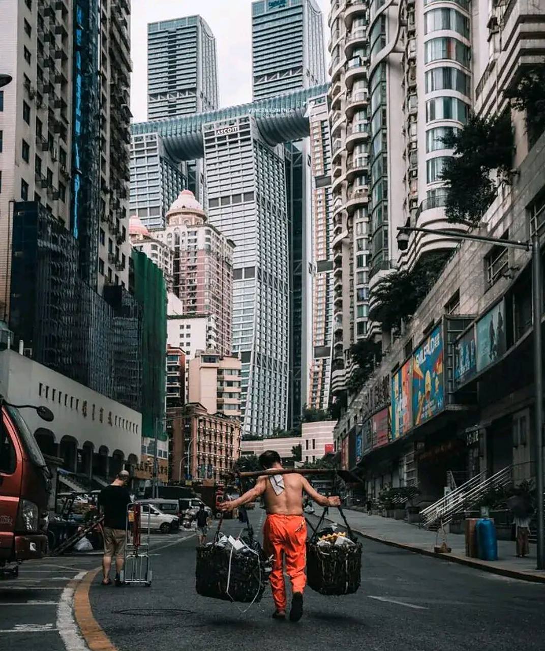 照片中来福士大厦的那根横梁,就是仿照重庆棒棒军的棒棒而设计的,他们