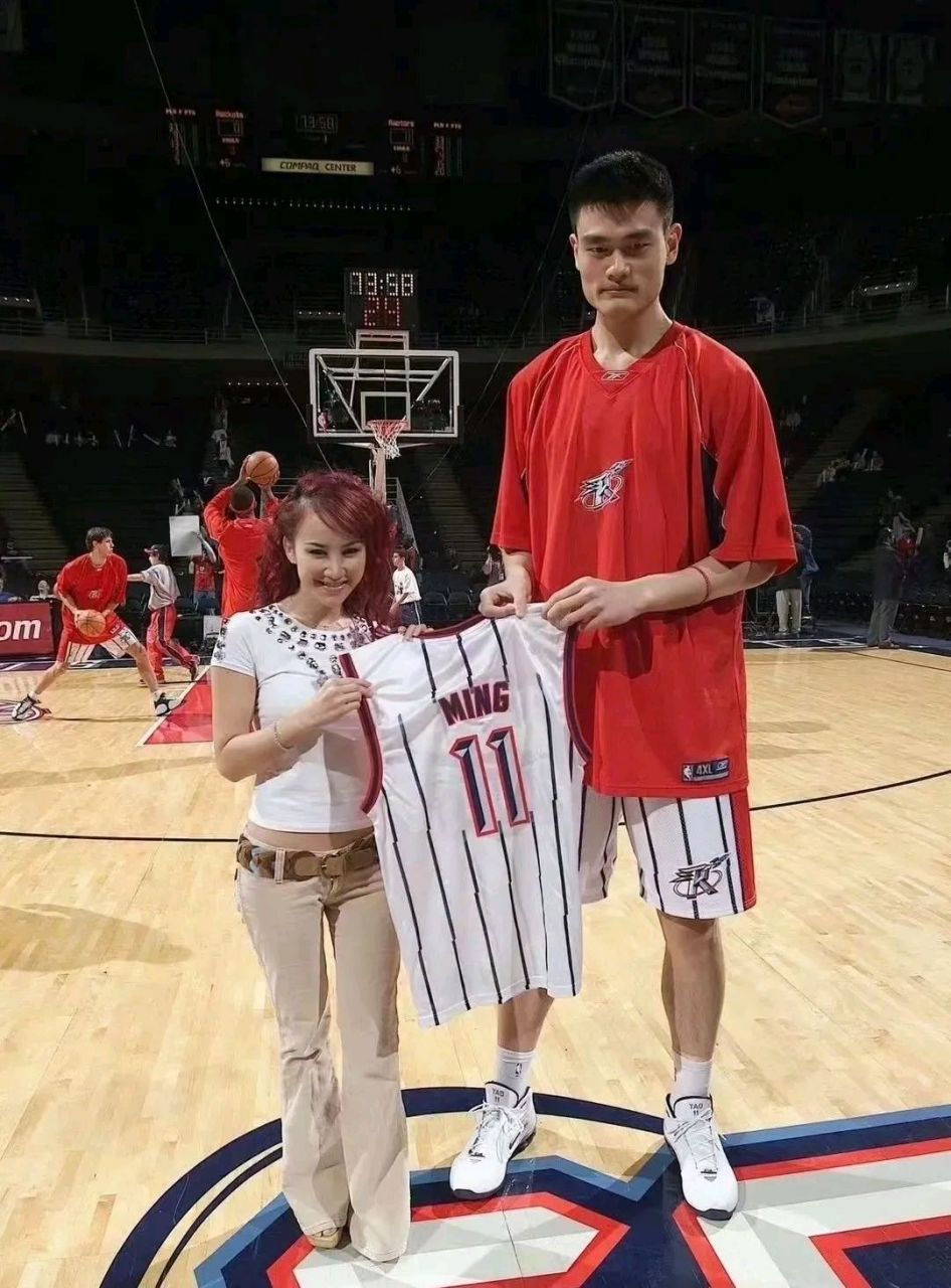 这是多年前李玟和姚明的一张合影照. 图中的李玟性感妖娆,姚明一脸青