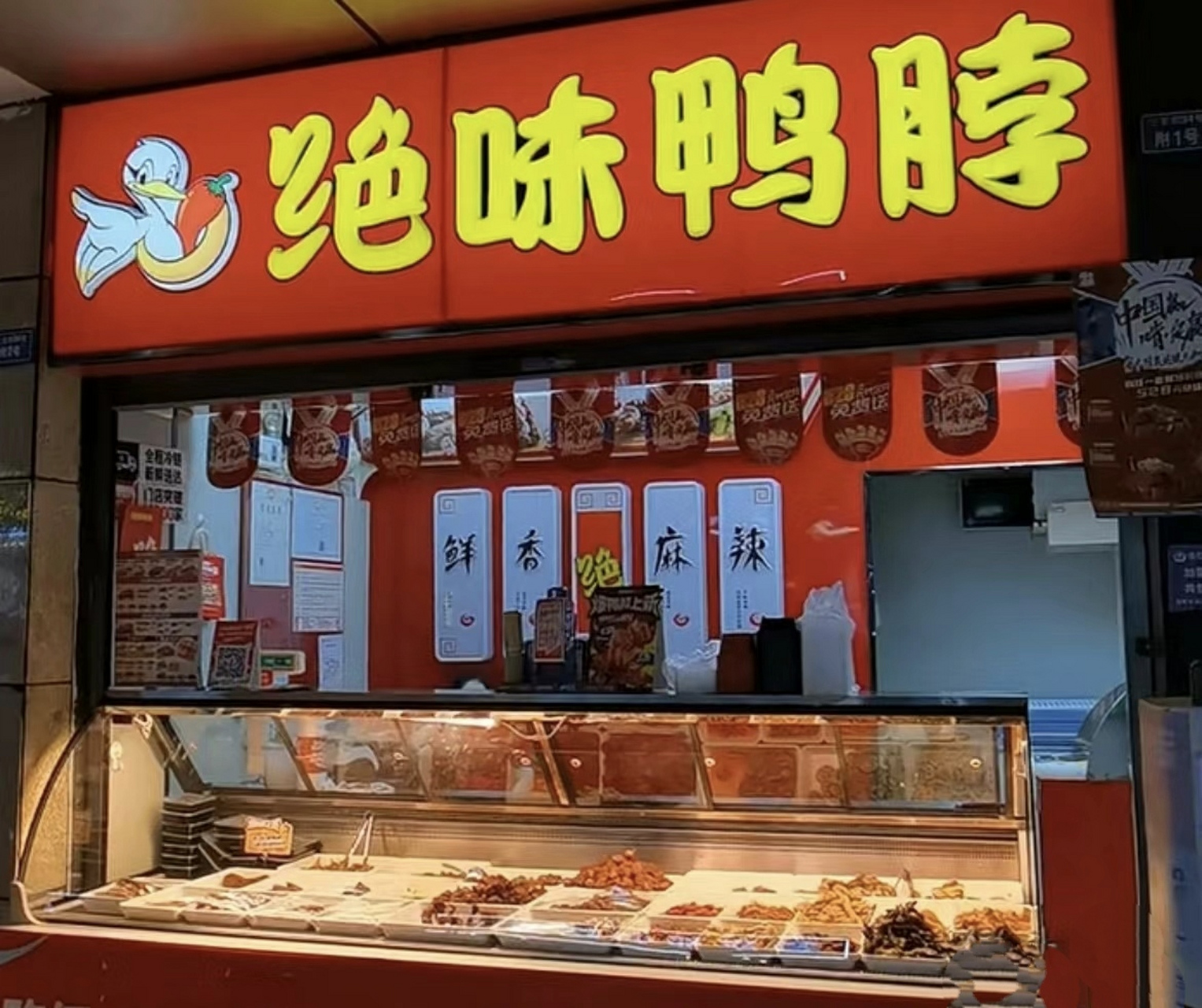 撑着伞来到了绝味鸭脖的店铺门口.