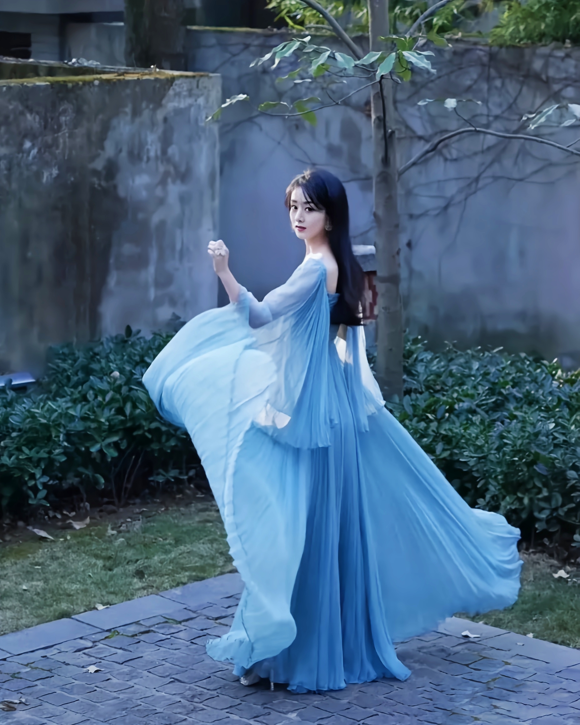 赵丽颖穿着一袭蓝色的薄纱礼服,自然间的华美转身,仙意融于温柔的阳光