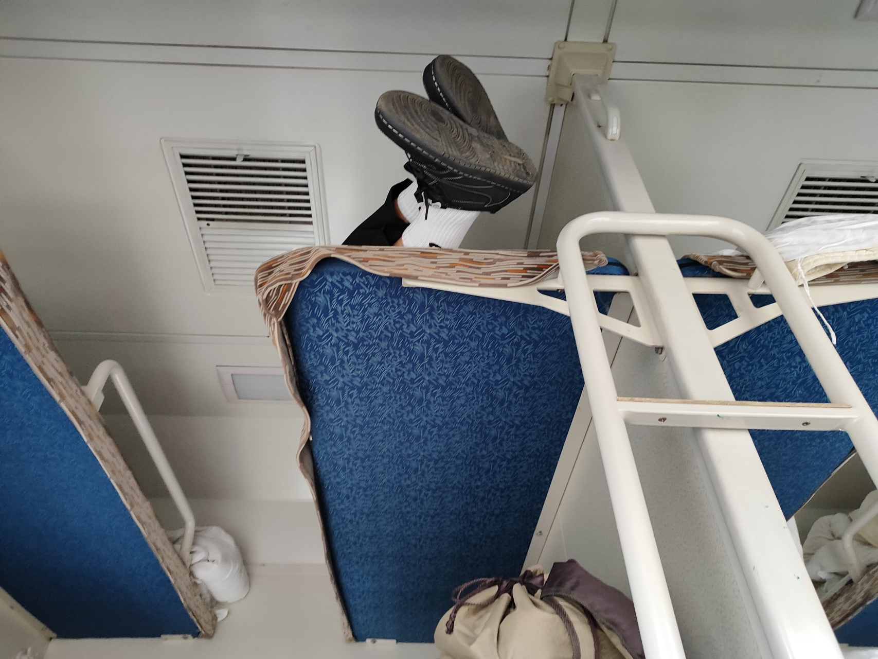 坐火车遇到让人头疼的事情 我的卧铺是中铺,上铺的小伙子穿着鞋子爬到