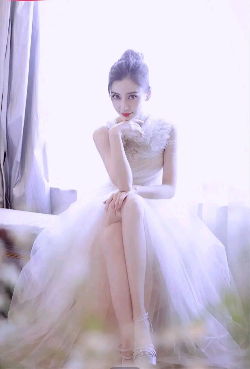 杨颖这套白色长裙穿搭,上半身采用金属链网状设计,吊带搭配蝴蝶结
