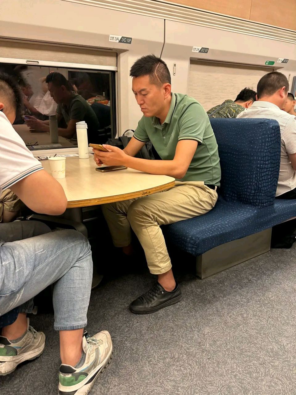 在动车的餐车里拿着水壶跟包包非要占着一个座位.