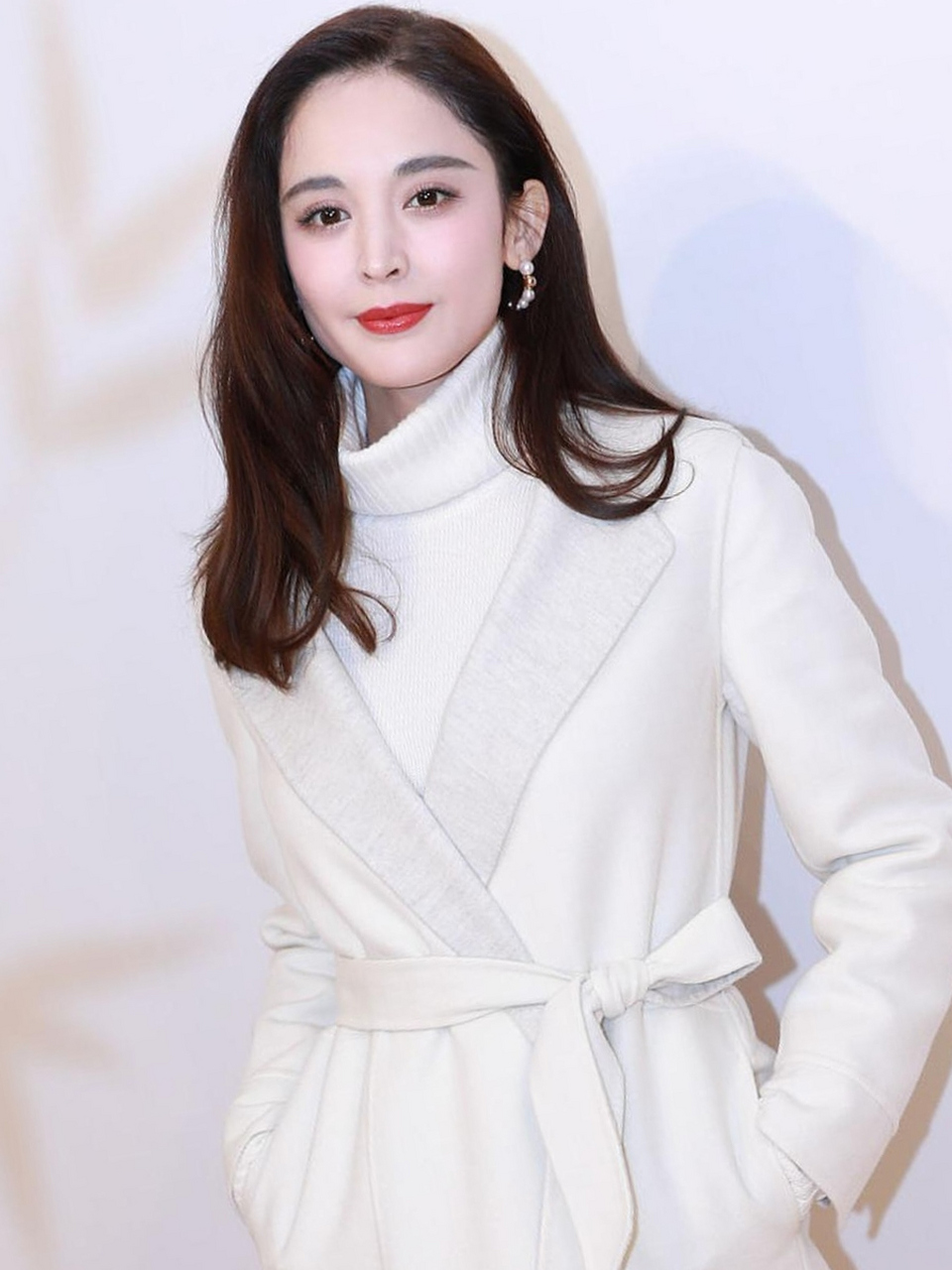 看古力娜扎长发披肩,穿着白色高领羊毛衫,撘配白色腰带裙,肤白貌美