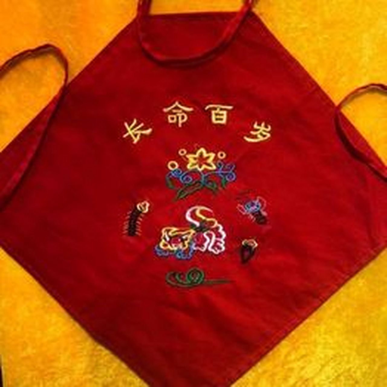 早年间,山东鲁南一带,小孩儿兴戴花兜兜,那兜兜的图案很别致,上面绣的