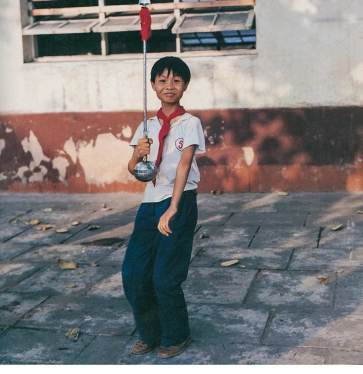 八十年代老照片,戴着红领巾的学生,拿着红缨枪正在摆拍,这一幕被日本