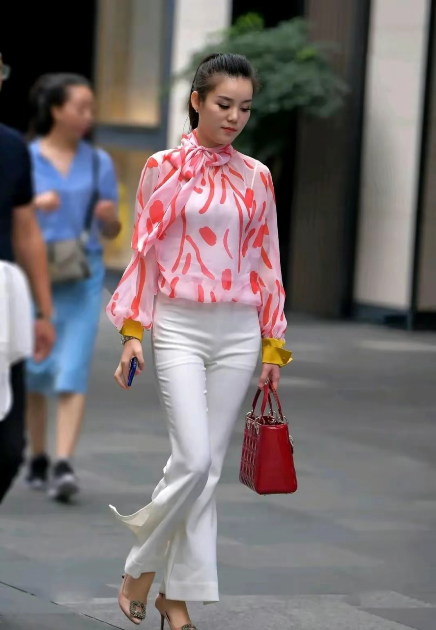 街拍美女:粉色飘带上衣搭配白色喇叭裤,干干净净的感觉,散发出独特的