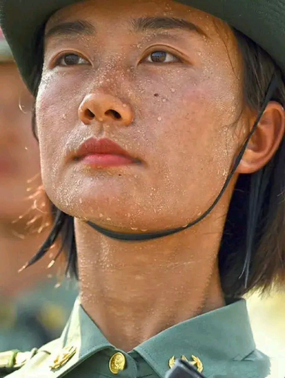 中国军人,其为人之勇毅不畏酷暑,全身都如洪水般地挥洒汗水,面容严肃