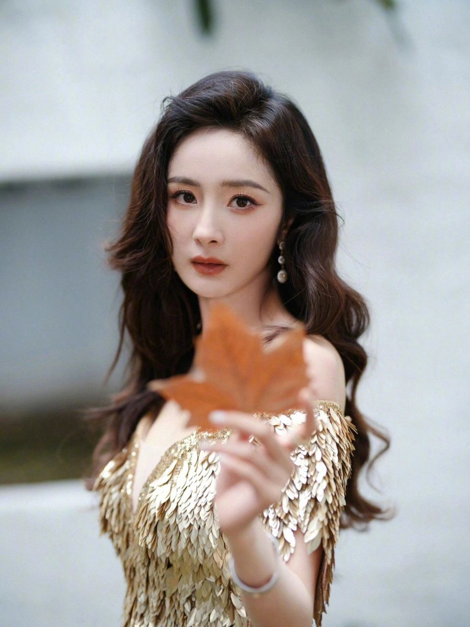 杨幂拍新造型好有女人味,妆容精致留着长卷发,穿着一袭金色亮片礼服裙