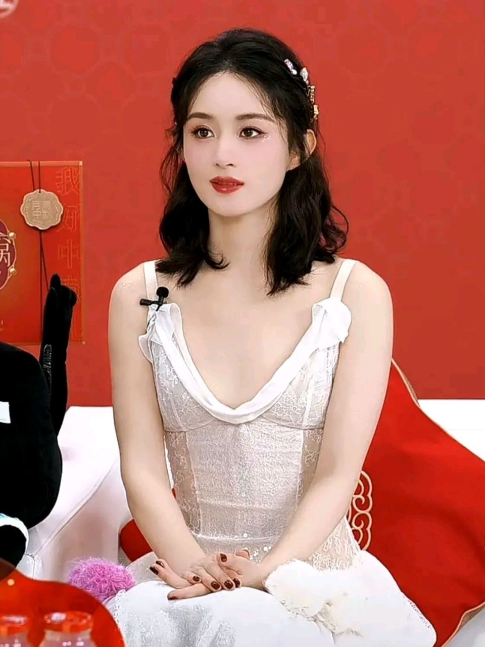 赵丽颖参加直播活动时,身穿一袭白色蕾丝深v吊带裙,秀出了她纤细的