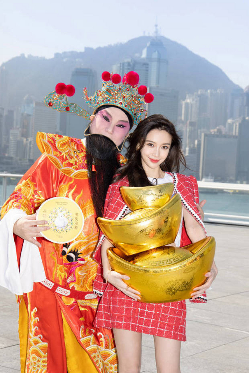 angelababy的大年初五迎财神的写真美照,她怀抱金元宝与被扮演的"财神