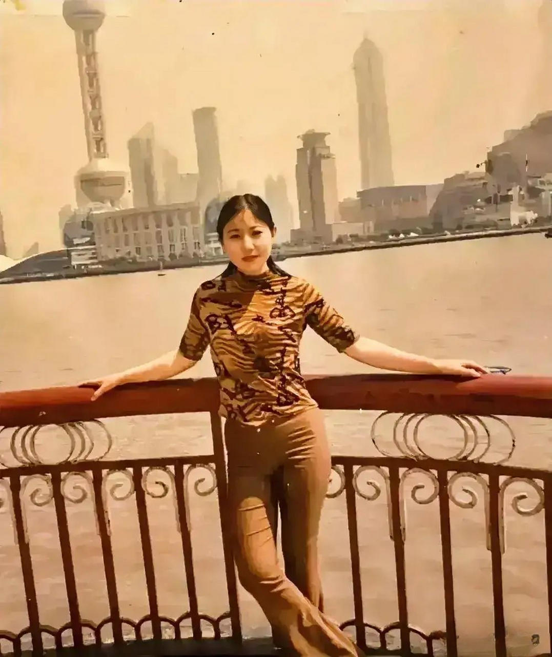 90年代,一位来上海打工的美女在外滩留影,照片中这位美女穿着一件紧身