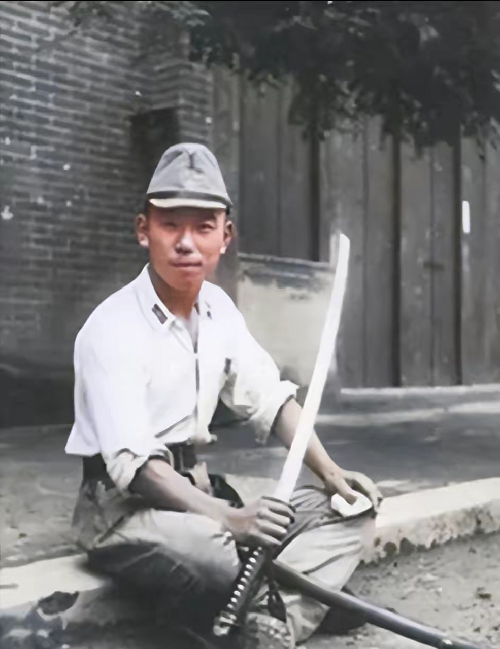 上面这张照片是一名手拿武士刀的日寇,他面带笑容地看着镜头,因为刚刚