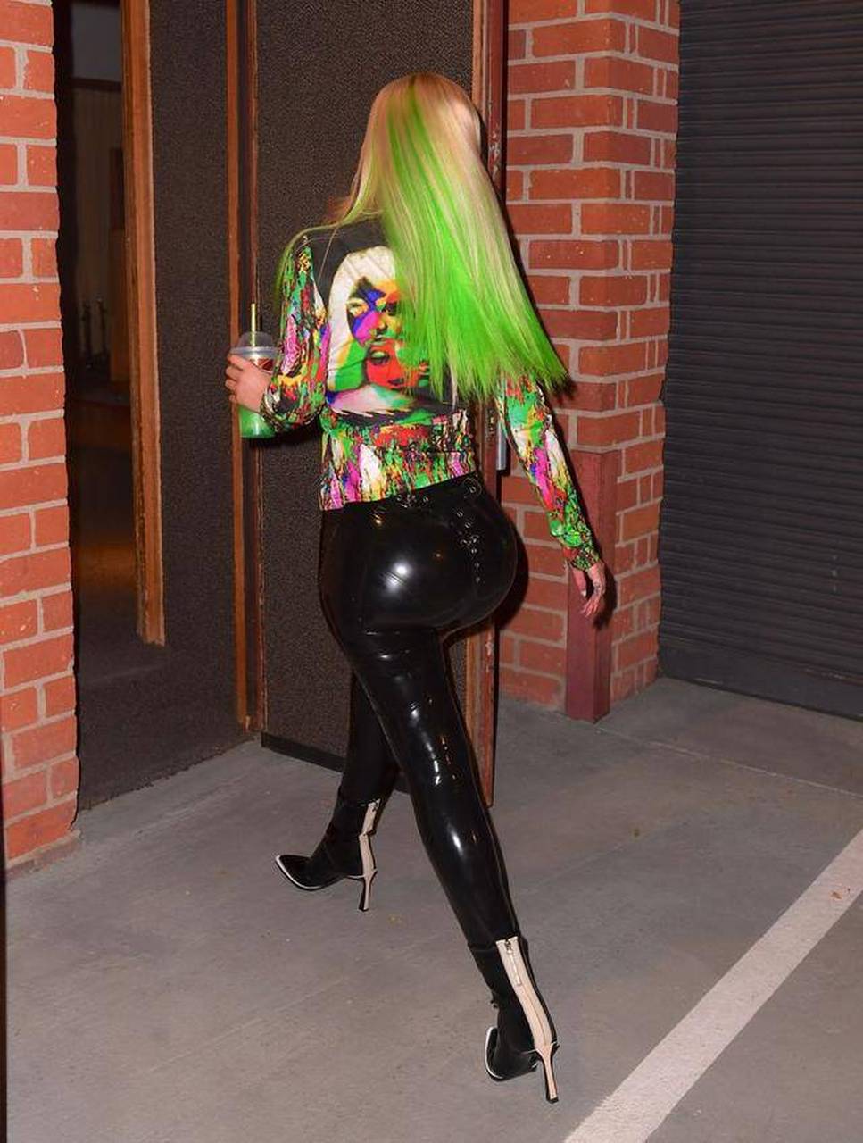 头发染成彩色,上衣彩色,裤子是亮皮裤的澳大利亚女歌手,词曲作者伊基