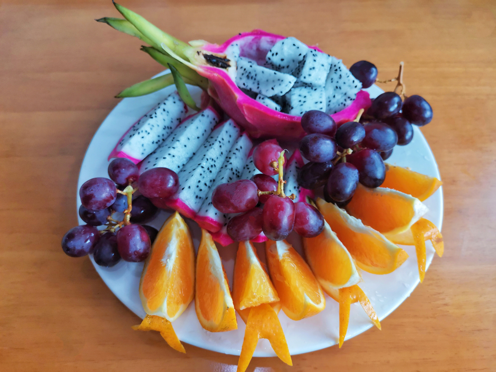 火龙果红提橙子拼盘 食材: 火龙果 1个 无籽红提 3小串 橙子 1- 2个
