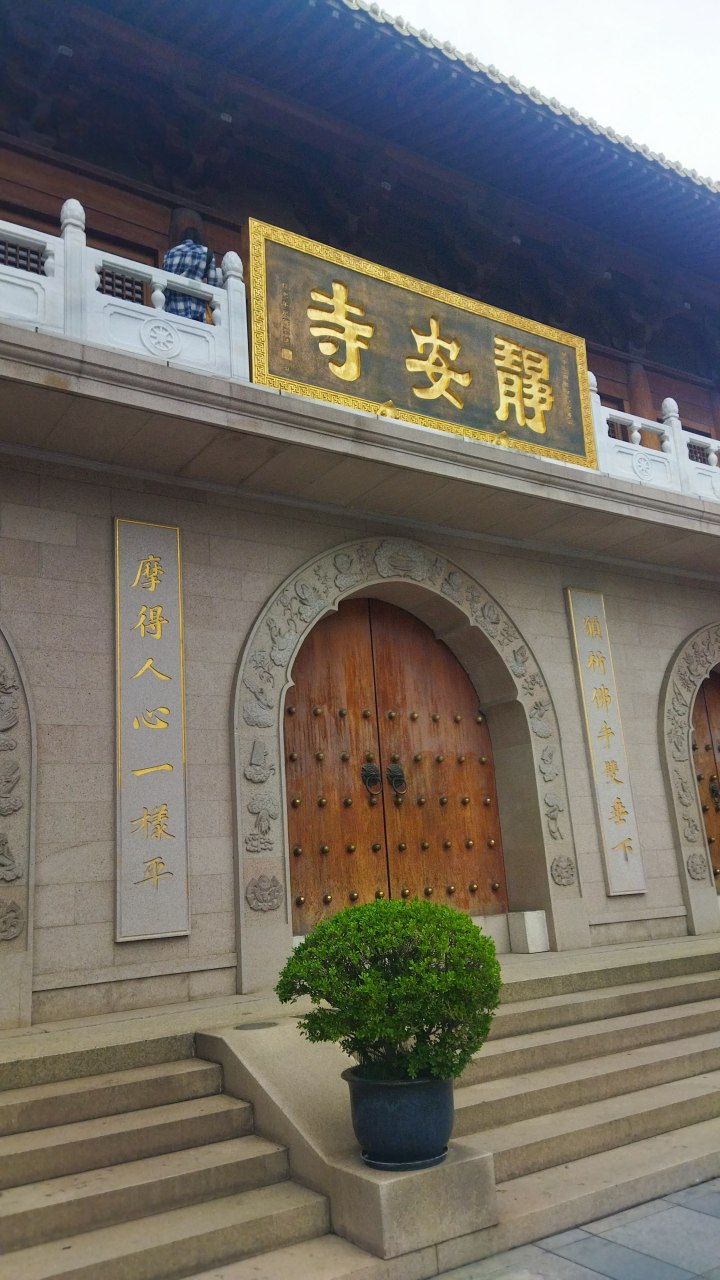 "愿祈佛手双垂下,摩得人心一样平" 静安寺大门题联.