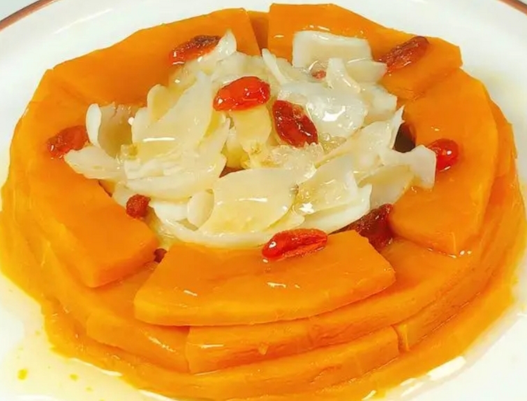 南瓜去皮,再改刀切片,在盘中摆一个圆形,把泡好的百合放到上面,再放上