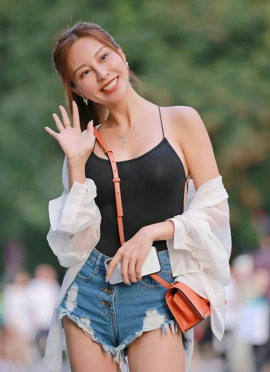 街拍穿搭:今天街拍时尚,牛仔热裤配小吊带,展现魅力冻龄,完美显长腿.