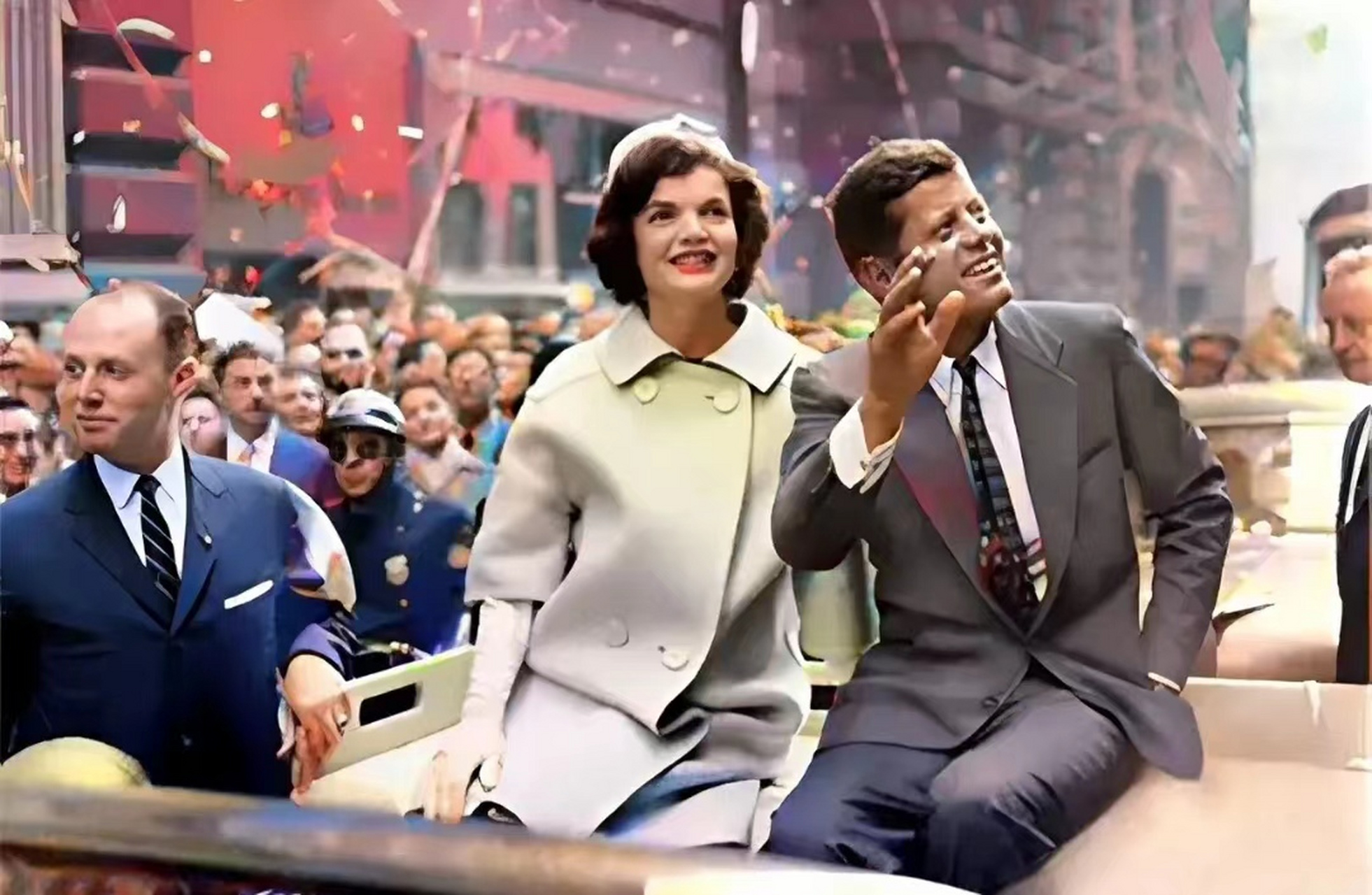 60年代,肯尼迪与夫人杰奎琳坐在汽车上正在感受来自拥护者的热情时的