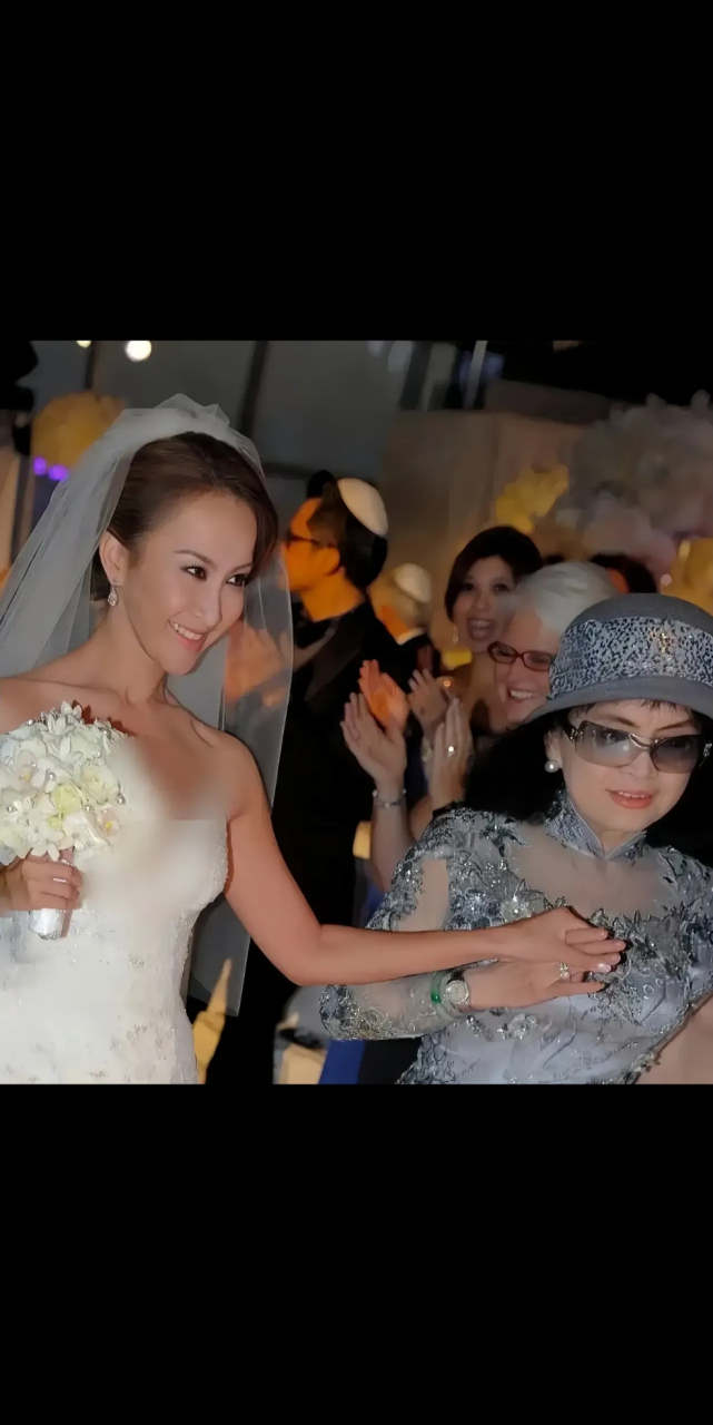 这是李玟结婚时的一张照片,牵着妈妈的手,她妈妈那个时候也有70多了吧