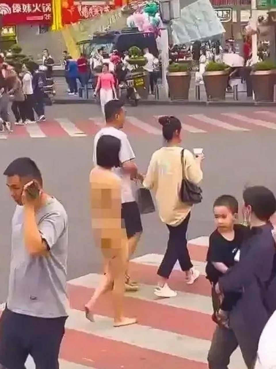 一位赤身裸体的女子旁若无人的在街道穿行;不知道这