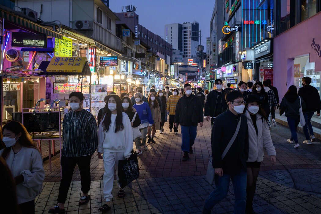 周日,在首尔弘大区的购物者。官员们担心,对流感疫苗安全性的担忧可能会破坏抗击新冠病毒,以及研发针对大流行的疫苗的努力。