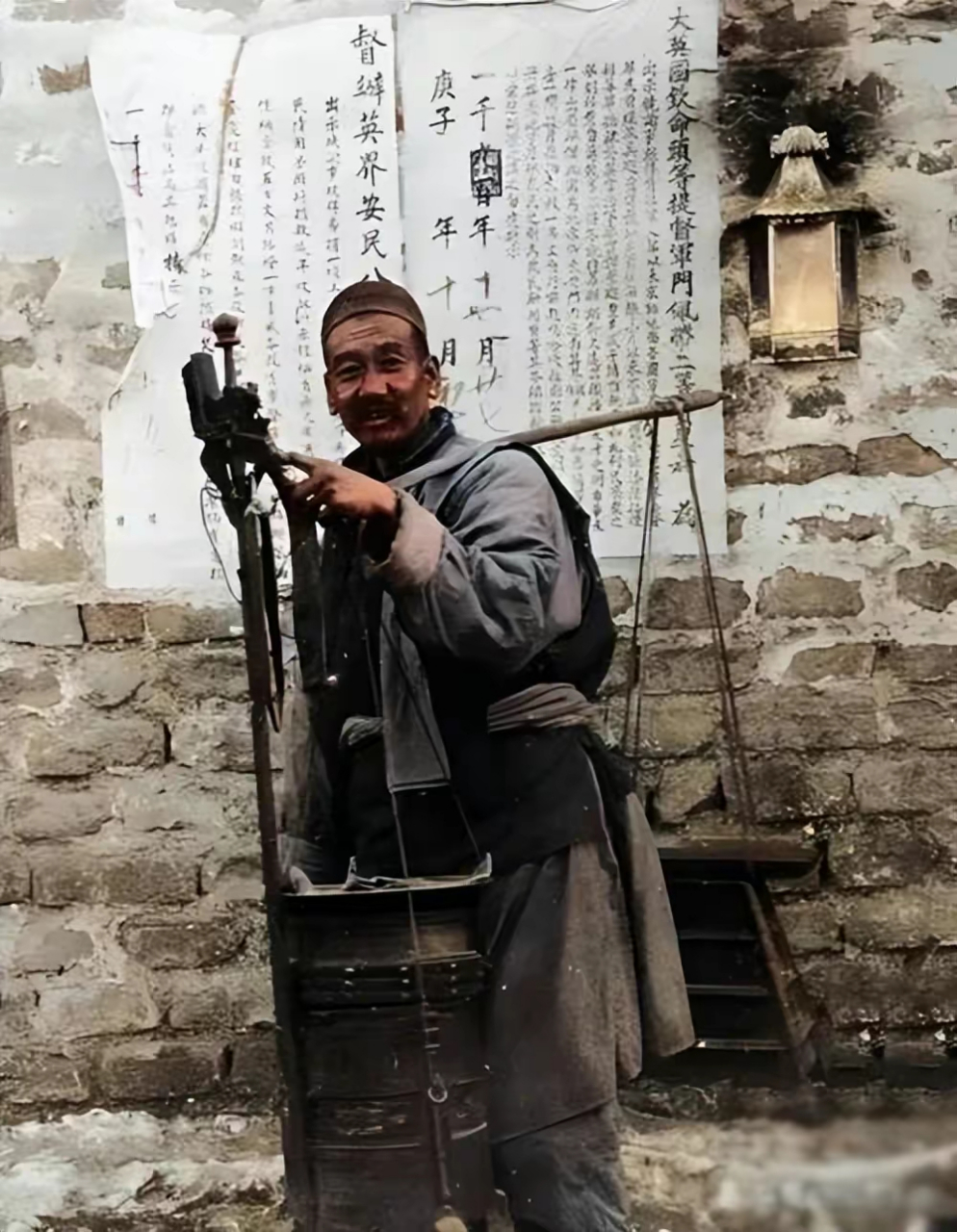 一名剃头匠正挑着他的全部干活的工具走街串巷的招揽生意,在挑子的