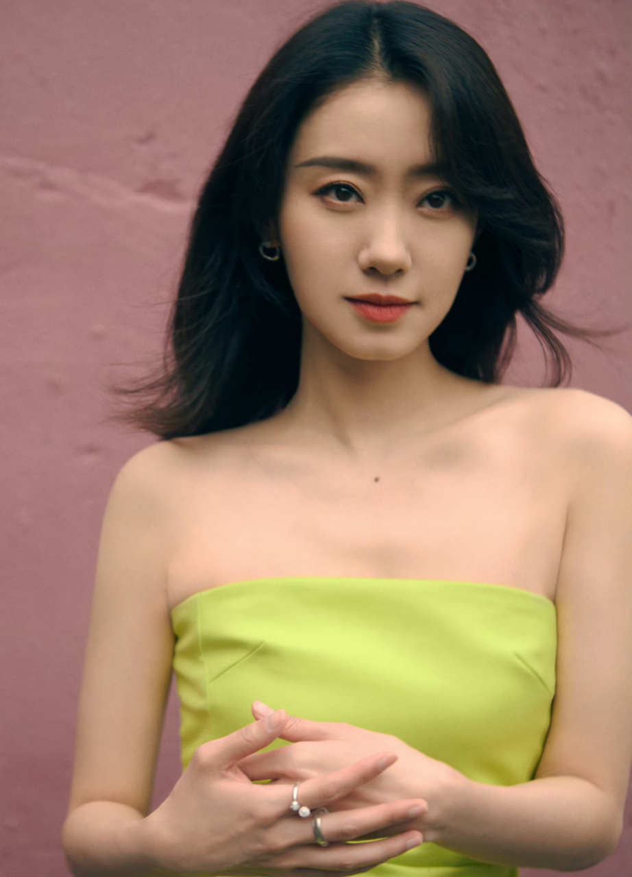 张小斐身着绿色抹胸裙,展现出了她优雅的气质和内敛的魅力.